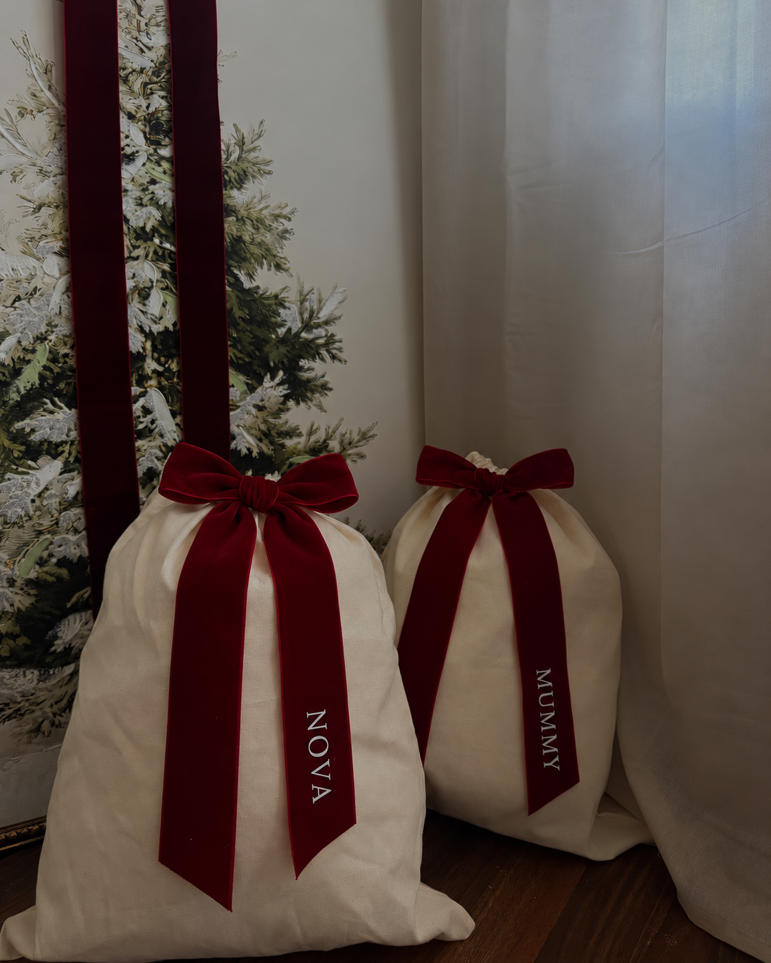 Personalised Christmas gift sacks beside a Christmas tree